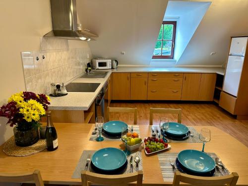 a kitchen with a table with blue plates and fruit on it at Hotel Modrásek in Kašperské Hory