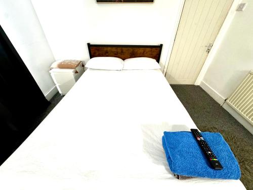 a bed with a remote control sitting on top of it at Wembley property in London
