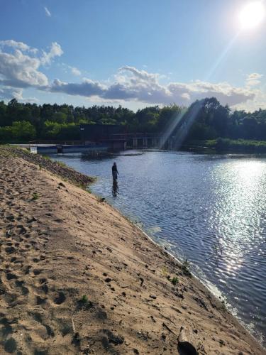 a person standing in the water in a lake at Domek nad Wkrą, okolice Sochocina, kajaki 
