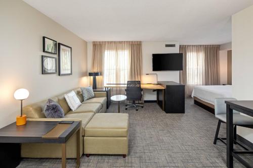 a hotel room with a couch and a bed and a desk at Residence Inn by Marriott Whitby in Whitby