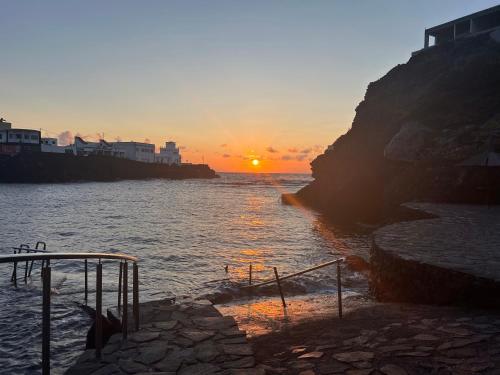 a sunset over a body of water with the sun setting at LAR Tamaduste in Tamaduste