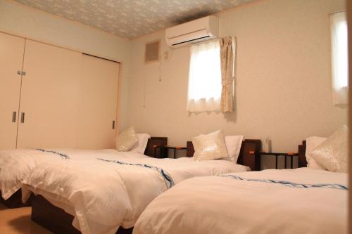 sypialnia z 3 łóżkami i oknem w obiekcie Yamanakako Resort House - Vacation STAY 22027v w mieście Yamanakako