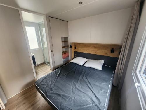 a small bedroom with a bed and a window at Mobilhome dans les Pins in Seignosse