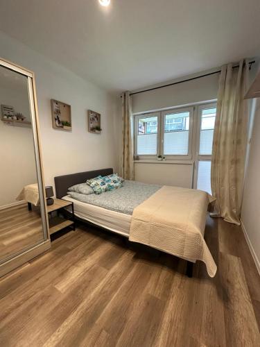 a bedroom with a bed and a large window at Apartamenty Modrzewiowa Enklawa in Debina