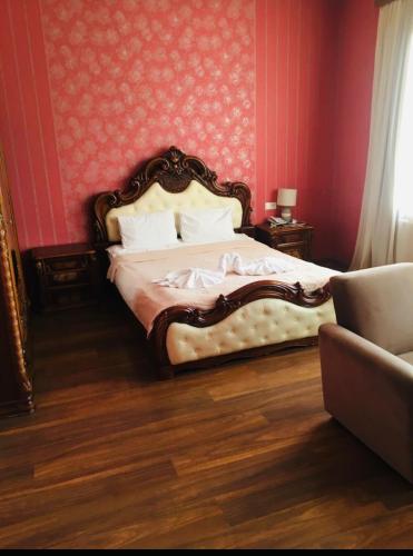a bedroom with a bed in a red wall at Hotel RichI G A in Tbilisi City