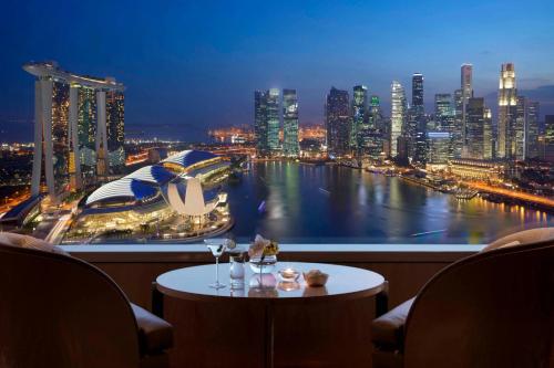 a room with a view of a city at night at The Ritz-Carlton, Millenia Singapore in Singapore