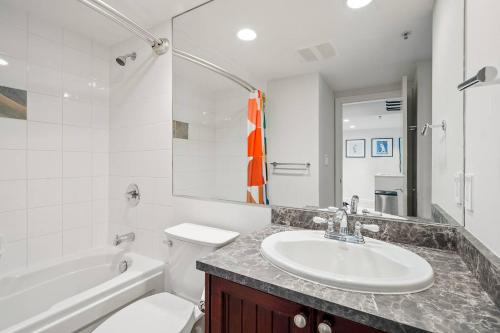 a bathroom with a sink and a toilet and a tub at 1BR Stylish Condo central Village Location with Private Balcony in Whistler