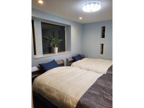 two beds in a room with a window at Seaside Garage Shima - Vacation STAY 39344v in Shima