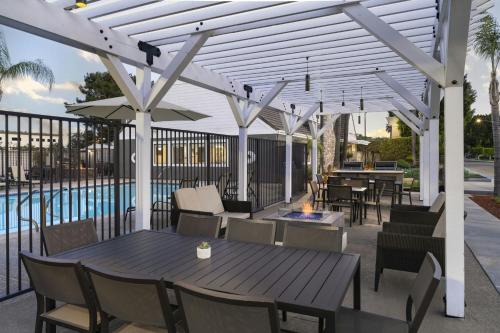 a patio with tables and chairs and a fire pit at Residence Inn Pasadena Arcadia in Arcadia