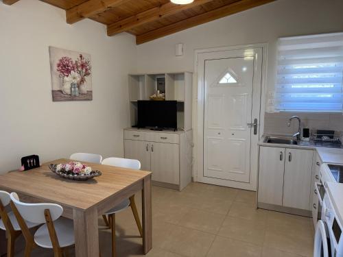 a kitchen with a table and chairs and a kitchen with a sink at The Wooden Nest in Asgourou
