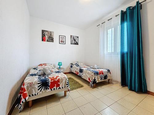 une chambre avec deux lits et une fenêtre dans l'établissement Maison avec jardin privatif à 3KM des plages, à Fréjus