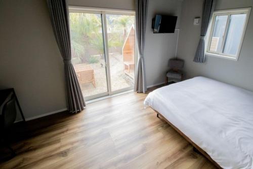 Un dormitorio con una cama y una ventana grande en LOCALINO STAY AOSHIMA - Vacation STAY 17893, en Miyazaki