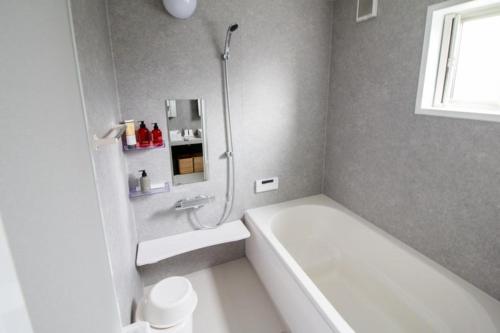 y baño con ducha y bañera blanca. en LOCALINO STAY AOSHIMA - Vacation STAY 17893, en Miyazaki