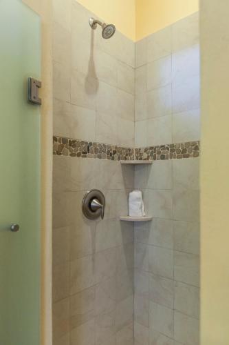 a bathroom with a shower with a towel on a shelf at Beach Break Suites Sayulita in Sayulita
