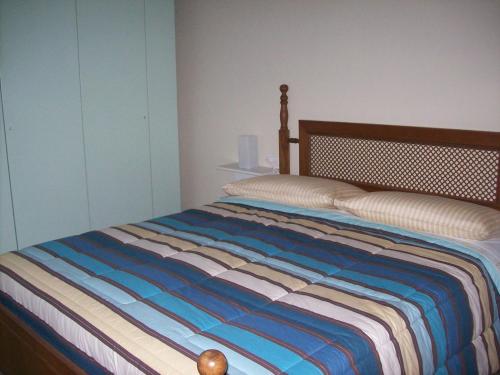 a bedroom with a bed with a striped comforter at La Bottega Del Falegname in Vanzaghello