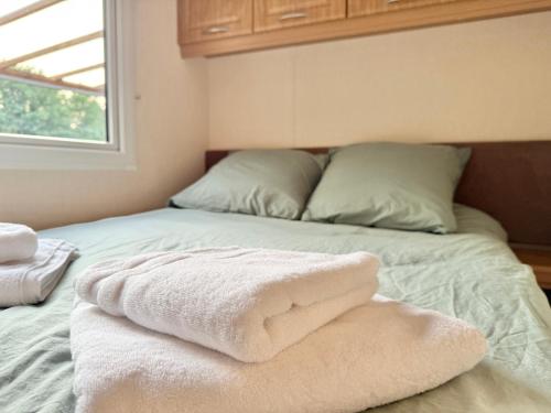a bed with two pillows and two towels on it at My Maui Home in Salles