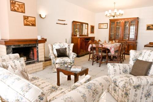 a living room with a fireplace and a table and chairs at Mediterranean Villa in St. Paul's Bay