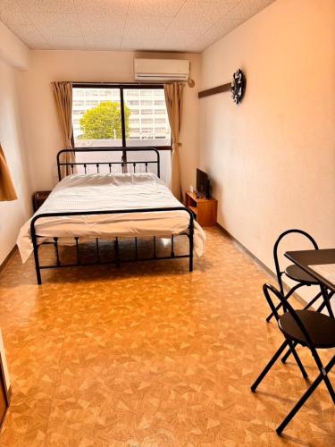 a bedroom with a bed and a table and chairs at Hare no hi Hakushima - Vacation STAY 94984v in Hiroshima