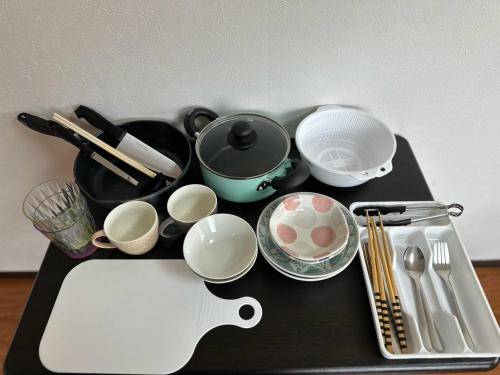 a black table with bowls and cups and a guitar at Hare no hi Hakushima - Vacation STAY 94984v in Hiroshima