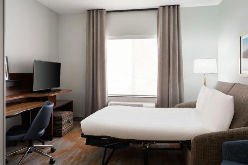a hotel room with a bed and a desk and a window at Fairfield Inn & Suites by Marriott Moab in Moab