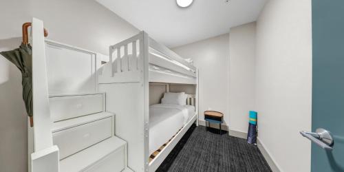 a white bedroom with a bunk bed in it at Kimpton Schofield Hotel by IHG in Cleveland