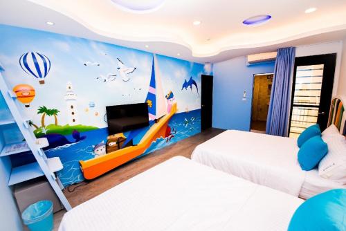 a bedroom with two beds and a mural of a boat at Zih Yue Tong Homestay II in Magong