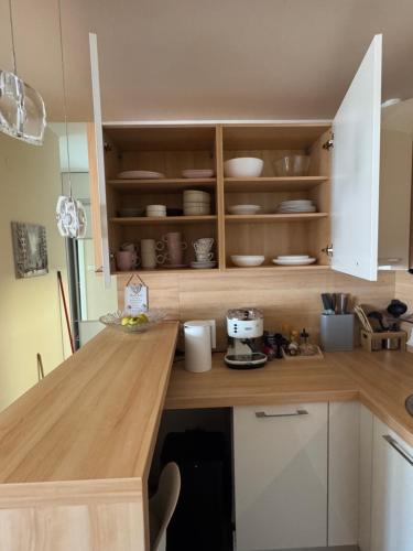 Una cocina con gabinetes blancos y una encimera de madera. en Tre Family, en Budva