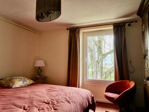 une chambre avec un lit, une fenêtre et une chaise dans l'établissement La grange du Luberon, à Bonnieux