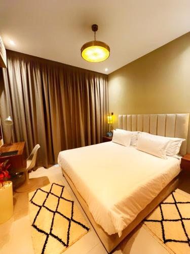 a bedroom with a large white bed and a desk at Cruiser Mogador Essaouira in Essaouira
