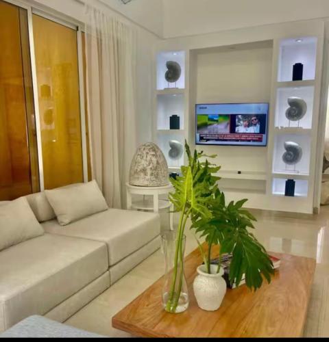 a living room with a white couch and a tv at Villa Puntacana Village near by the airport and beach in Punta Cana