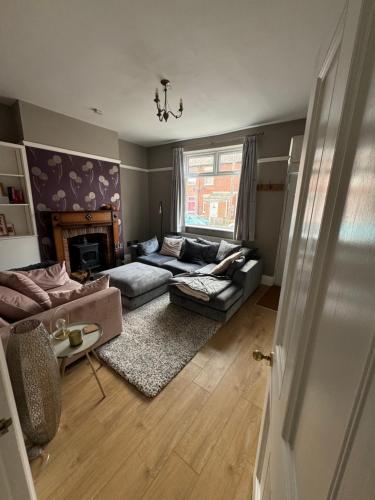 a living room with a couch and a fireplace at The Perfect Bedroom to Rent in Altofts