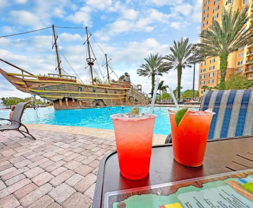 two cocktails sitting on a table next to a pool at Lake Buena Vista Resort Village and Spa, Near Disney in Orlando