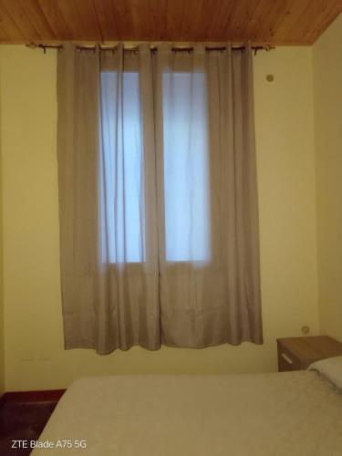 a bedroom with a bed and a window with curtains at A casa di Anna - vista mare nel centro storico in Amantea