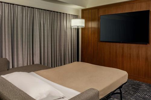 a hotel room with a bed and a flat screen tv at Renaissance Boston Seaport District in Boston