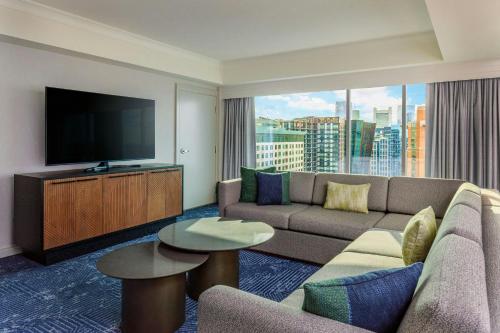 a living room with a couch and a flat screen tv at Renaissance Boston Seaport District in Boston