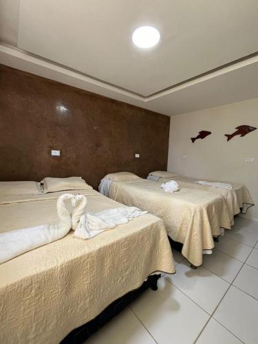 three beds in a room with bats on the wall at Pousada Solmar in Japaratinga