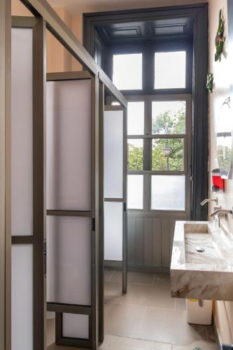 a bathroom with a glass door and a sink at Hostel Bemaro Mexico City in Mexico City