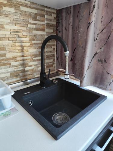a kitchen sink with a black counter top at Perla Bocșei - Apartament Etaj 4 in Bocşa