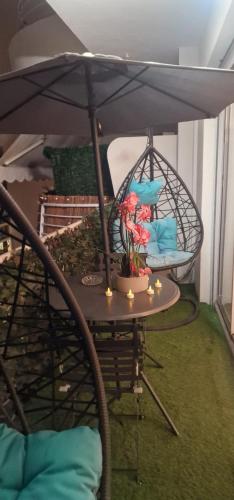 une table de patio avec un parasol et une chaise dans l'établissement Appart 1 pièce pointe de la Croisette à cannes, à Cannes