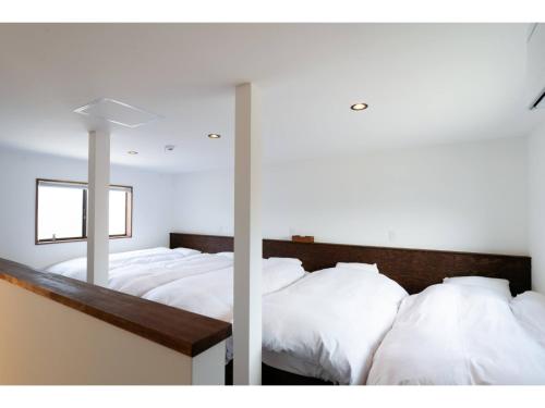 sypialnia z 2 łóżkami z białą pościelą i lustrem w obiekcie Tengu Tabine-Cotengu Tabine - Vacation STAY 04527v w mieście Kanazawa