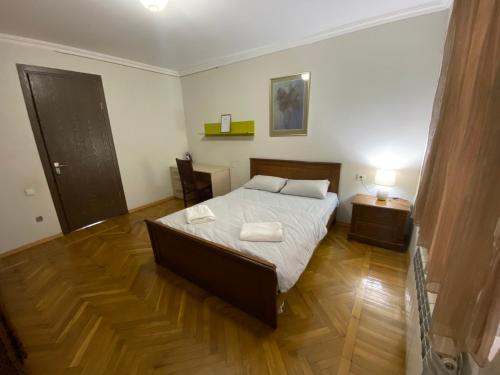 a bedroom with a bed and a wooden floor at Villa Visteria with terrace in Batumi