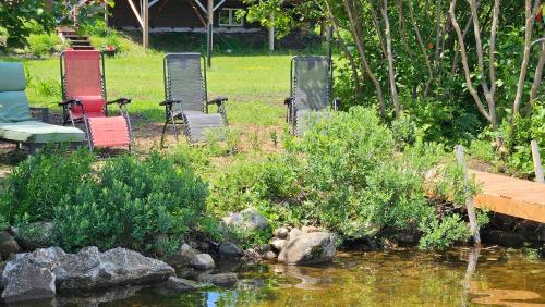 a group of chairs sitting next to a pond at Chalet Mathis in Saint-Raymond