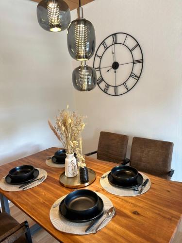 a dining room table with a clock on the wall at Royal Haus Soltau in Soltau