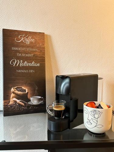 a coffee maker and a cup of coffee on a table at Royal Haus Soltau in Soltau