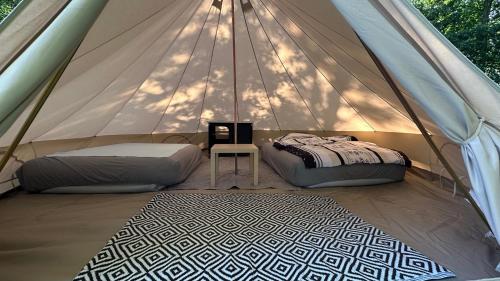 a tent with two beds and a table in it at Glamping Stodoła Tent in Ściegny