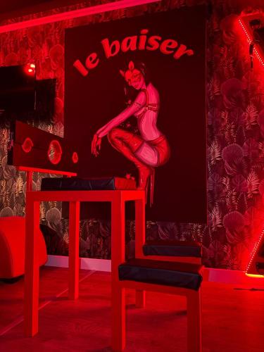 a red room with a picture of a woman on a wall at Le baiser 2 Love room du plaisir interdit in Saint-Arnoult
