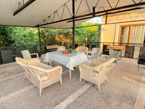 a patio with a table and chairs and a piano at Villa Visteria with terrace in Batumi