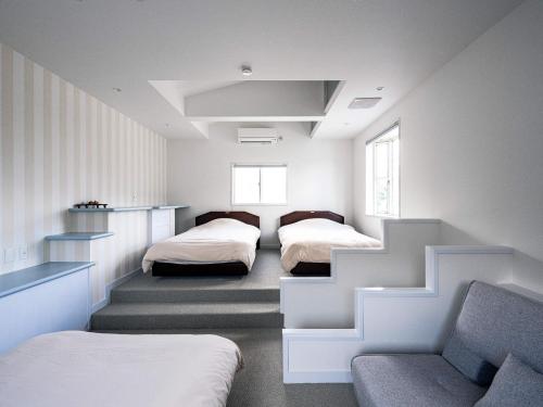 a bedroom with two beds and a staircase at Sauna & Cottage SHIOJINO - Vacation STAY 06218v in Karatsu