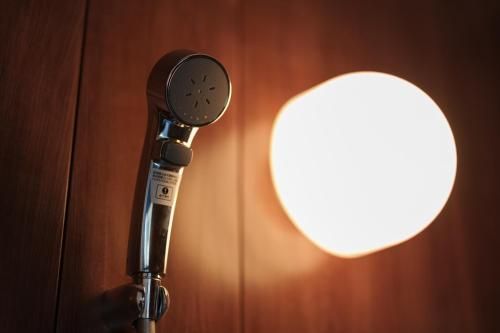 a microphone in front of a wall with a light at Mountain Green D "Japanese Heart" - Vacation STAY 08400v in Yufuin