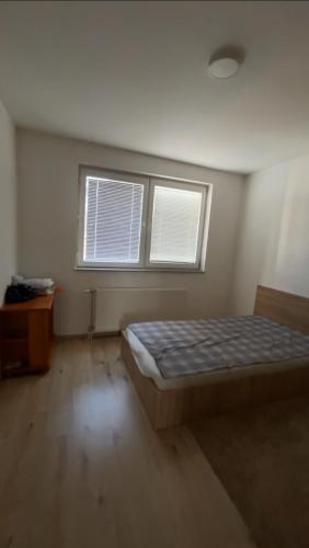 a bedroom with a bed and two windows at 2BR apartment in Fushe Kosova in Kosovo Polje